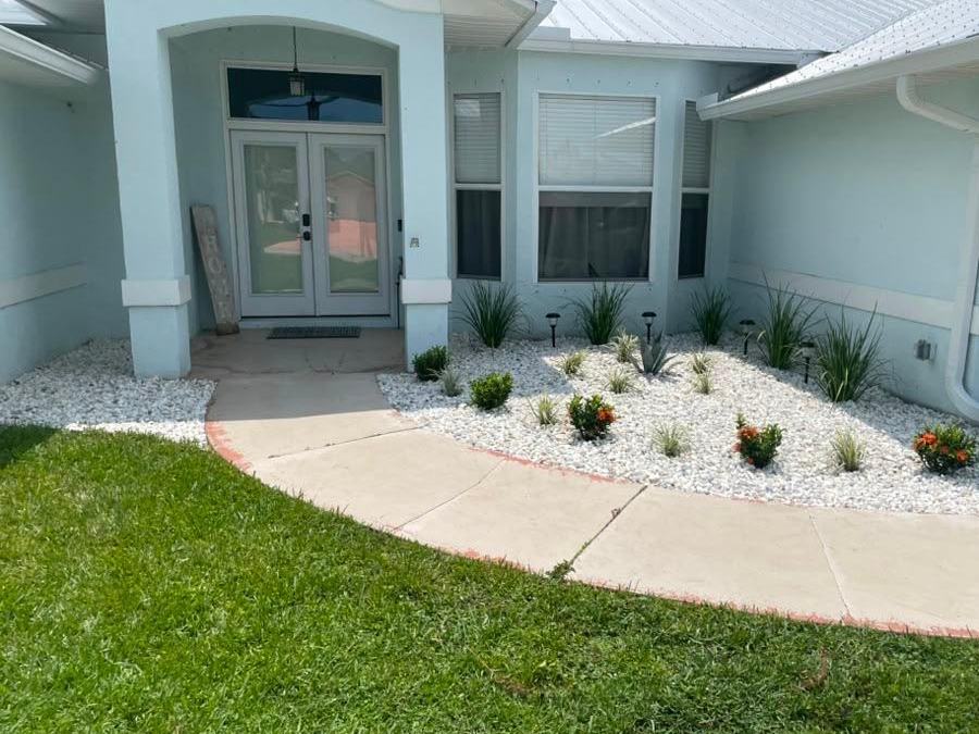 Finished white decorative rock bed with new plantings at a Royal Palm Beach, FL home