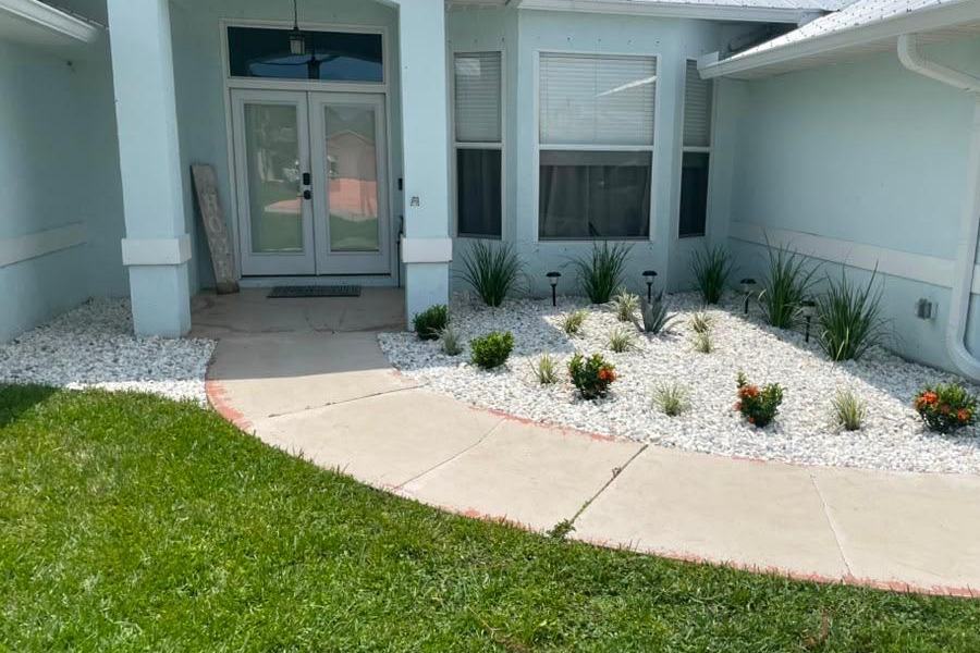 Finished white decorative rock bed with new plantings at a Royal Palm Beach, FL home